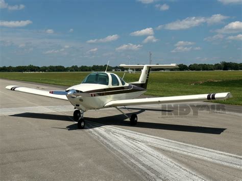 Beechcraft Skipper on grass strip with rural background