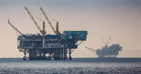Bell 407 flying over offshore oil platform during transport mission