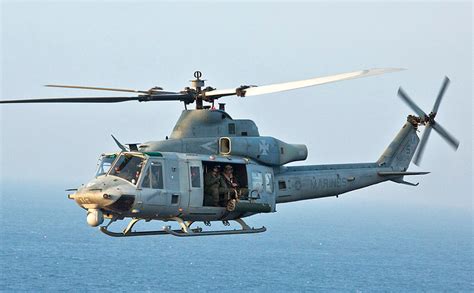 Bell UH1Y Venom Marine Corps utility helicopter flying over terrain