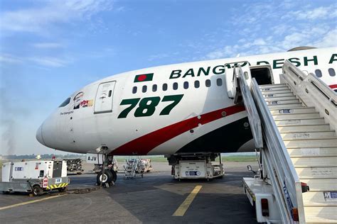 biman bangladesh airlines at sunset runway with boarding passengers