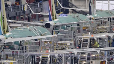 Boeing 737 MAX production line with workers assembling fuselage sections