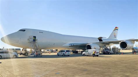 Boeing 747-8 cargo aircraft loading freight containers at cargo terminal