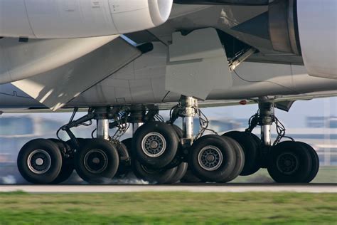 boeing 747 emergency landing with blown tire showing smoke and rubber debris on runway