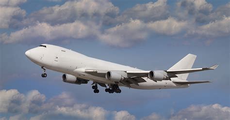 Boeing 747 freighter variant airborne with full cargo load, sunset background