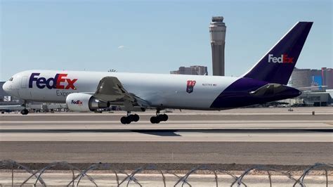 Boeing 767 in FedEx livery taxiing on airport apron in twilight