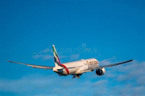 Boeing 777-300ER of Emirates climbing after takeoff with extended landing gear
