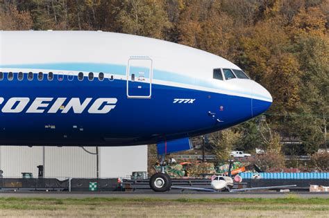 Boeing 777X widebody jet taxiing at airport terminal