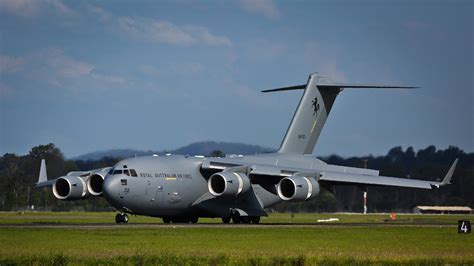 Boeing C-17 Globemaster III transporting military vehicles on runway