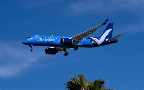 breeze airways a220 flying over florida coastline en route to caribbean destination