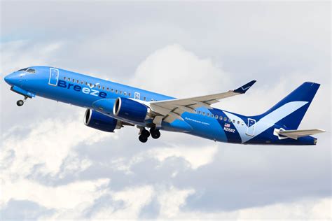 Breeze Airways A220 taking off over suburban U.S. airport