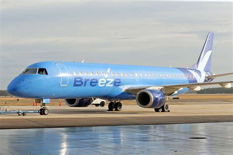 breeze airways jet on runway with key west palm trees in view
