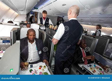 british airways cabin crew serving water in cups during us flight