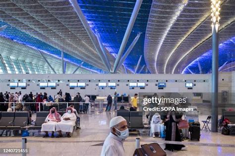 busy Jeddah airport terminal with multiple Saudi airlines aircraft at gates