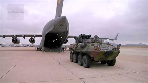 C-17 Globemaster unloading military vehicles with engines running