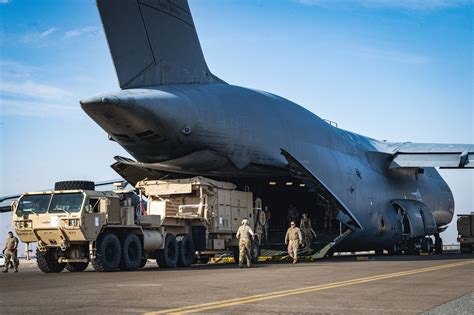 C-5M Galaxy rear ramp open with military vehicles