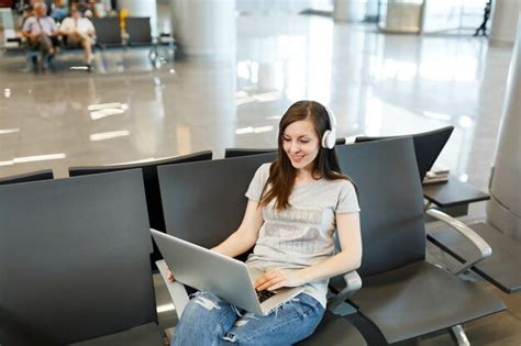 calm traveler meditating with headphones in busy airport terminal