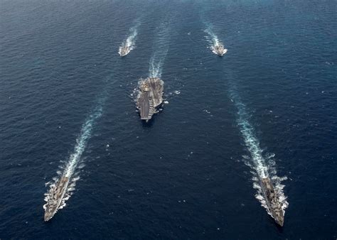 carrier strike group tight formation warships maneuvering at sea
