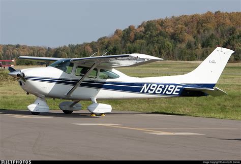 cessna 182 skylane on gravel airstrip with mountain backdrop
