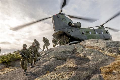 CH-47 Chinook performing pinnacle landing on mountain ridge
