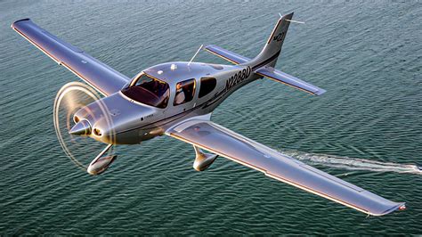 Cirrus SR22 taking off from a short grass strip runway