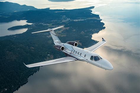 citation cj4 climbing over mountainous terrain in clear skies