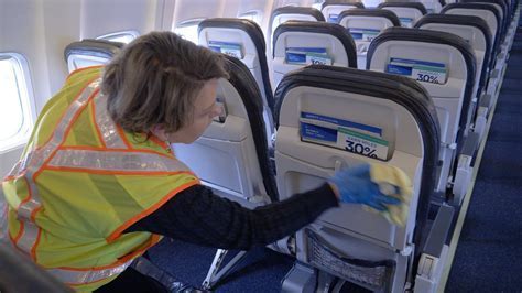 cleaning staff preparing cabin for next flight with disinfectants and cloths