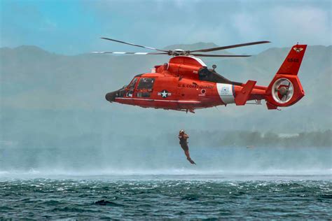 coast guard dolphin helicopter winching survivor from stormy ocean