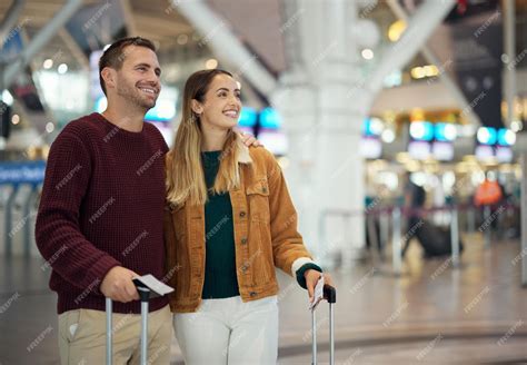 Couple looking at a departures board in an airport, ready for an adventure