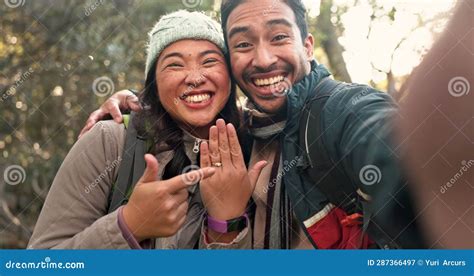 couple taking engagement selfie inside helicopter during mountain sunset flight