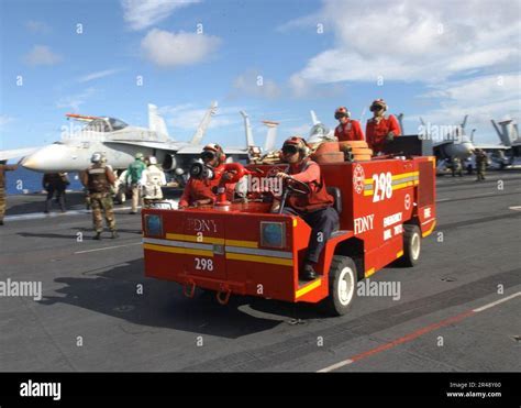Crash and salvage team extinguishing simulated aircraft fire on carrier deck during drill