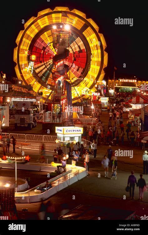 crowd watching sunset over cheyenne frontier days fairground carnival rides