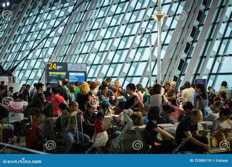 crowded airport departure gate with passengers boarding aircraft during peak travel season