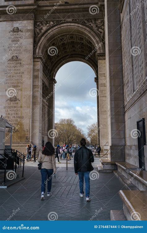 Crowds of tourists beneath the Arc de Triomphe during summer tourism season