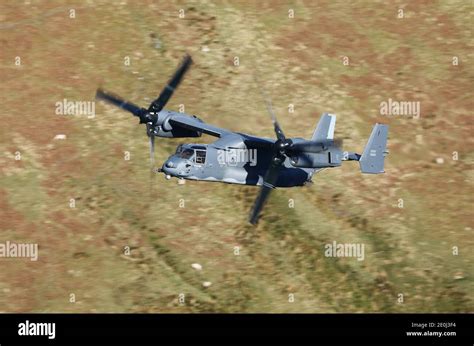 cv-22 osprey tiltrotor aircraft in forward flight mode over desert terrain