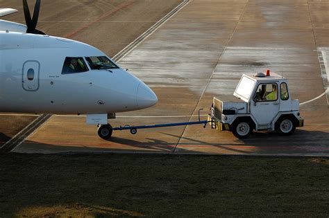 damaged aircraft towbar lying beside pushback tug after incident