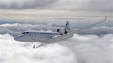 Dassault Falcon 8X three engine private jet flying above clouds
