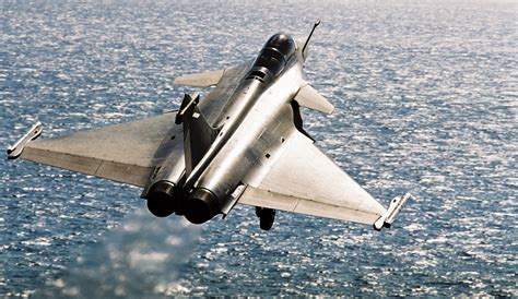 Dassault Rafale jet soaring above mountainous terrain, showcasing its sleek design and armament