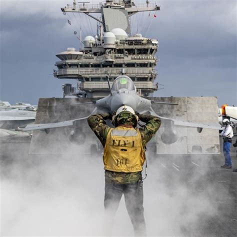 Dassault Rafale on aircraft carrier deck ready for takeoff with naval crew