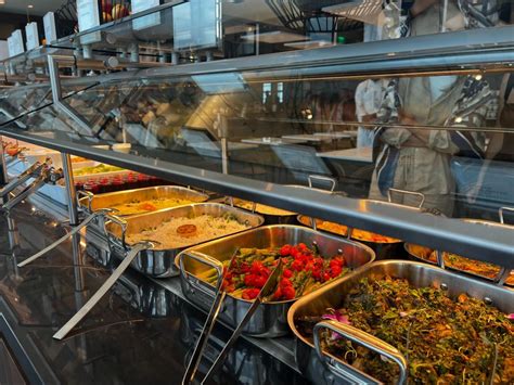 DCA Centurion Lounge buffet counter during breakfast service with fruits and pastries