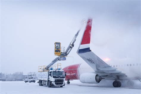 deicing trucks at major international airport during snowstorm