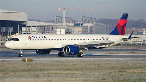 Delta Air Lines aircraft at an airport with October 2026 route network map