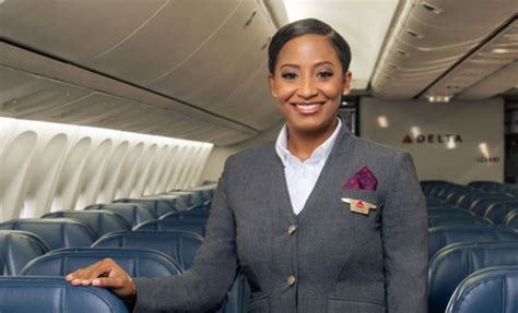 Delta Air Lines cabin crew smiling in uniform aboard aircraft