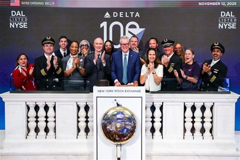 Delta CEO Ed Bastian speaking at centennial event with Delta logo backdrop