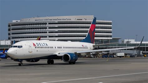 Delta maintenance engineers inspecting Boeing 737-900ER engine on wing