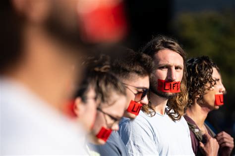 demonstration near Rossio station, activists with red tape over mouths and signs reading “Lisbon is not for sale”
