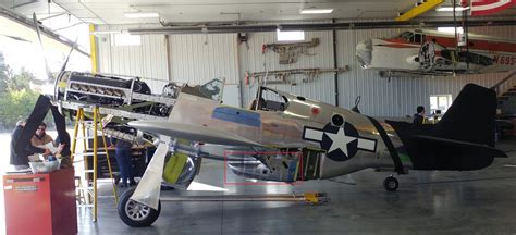 detailed restoration shot of P-51 Mustang scoop and cooling assembly in hangar lighting