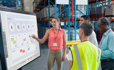 DHL Operations Supervisor reviewing KPIs on a tablet in a Livermore warehouse