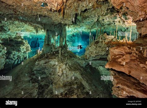 diver exploring crystalline cenote cave in Yucatán
