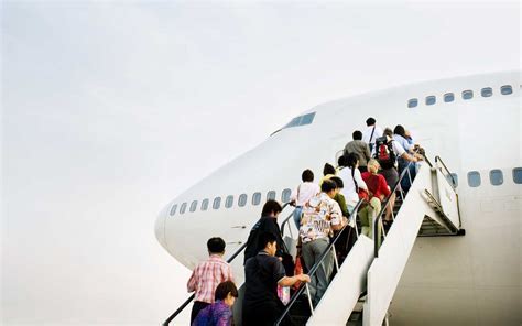 Diverse group of passengers boarding an airplane, with focus on friendly airline staff interaction