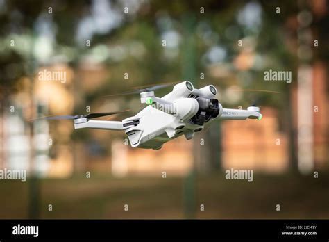 DJI Mini 3 hovering over a forest trail in daylight